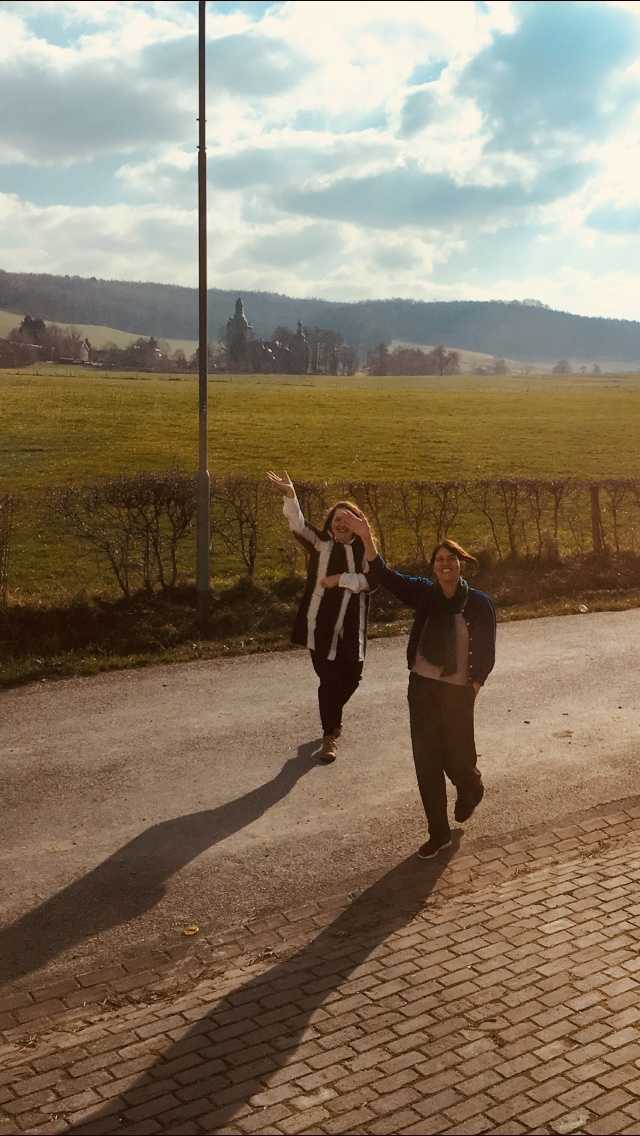 Gabriëlle Schleijpen (artistic director) & Jacq van der Spek a.k.a. Jackie Bacon ( roaming co-ordinator) waving goodbye to DAI-students leaving Epen after an intensive week of living and studying together. (2018, photographer unknown).