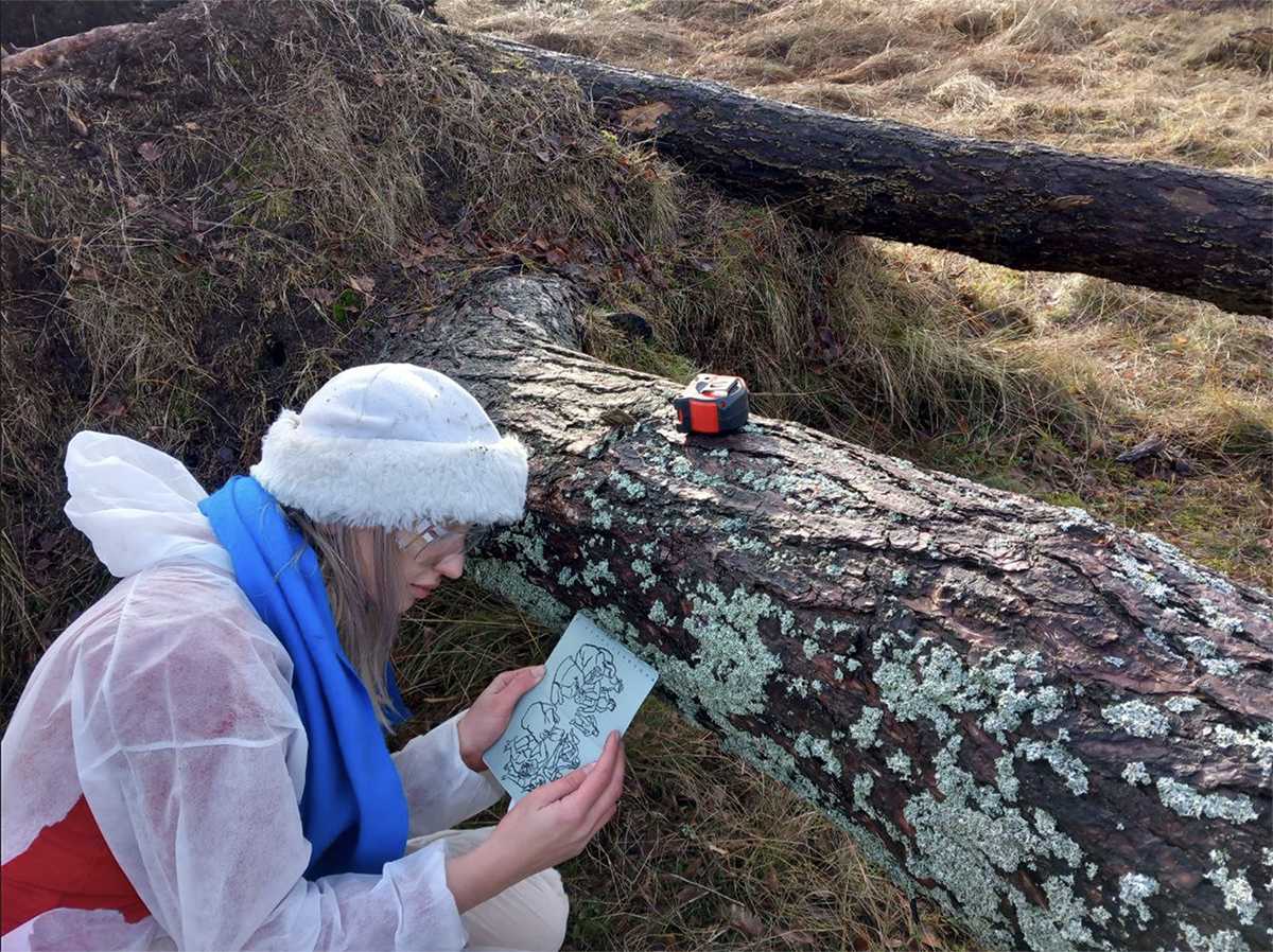 Weronika Zalewska comparing sketches of lichen to the real ones. Nida, January 2023. 