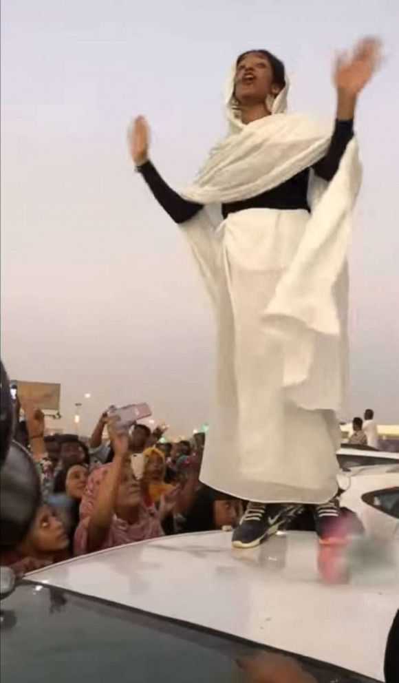 Alaa Salah, a 22-year-old architecture student in Khartoum reciting revolutionnary poetry, wwhile standing on the roof of a car. Khartoum, April 2019