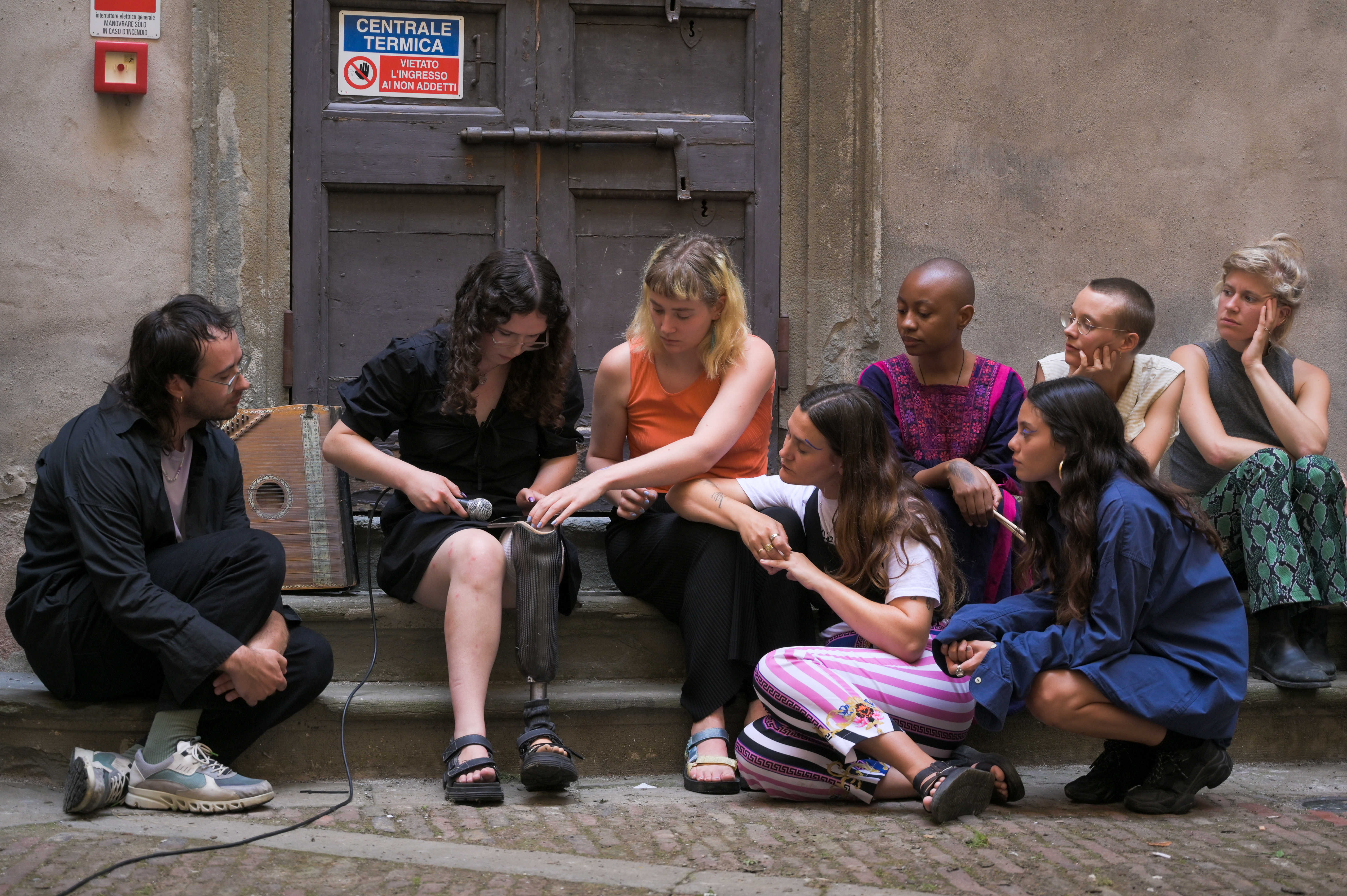 Dima’s Bracelet. Songs, Prayers, Stories and Spells ~ a COOP SUMMIT 2022 presentation by COOP study group On Tradition - Future Ancestors 2: Rurality and Law. Here, the members of the group are listening to a pre-recorded reading by Pelumi Adejumo. Location: BACO in Bergamo, Italy. Photo credit: Baha Görkem Yalim for DAI.  