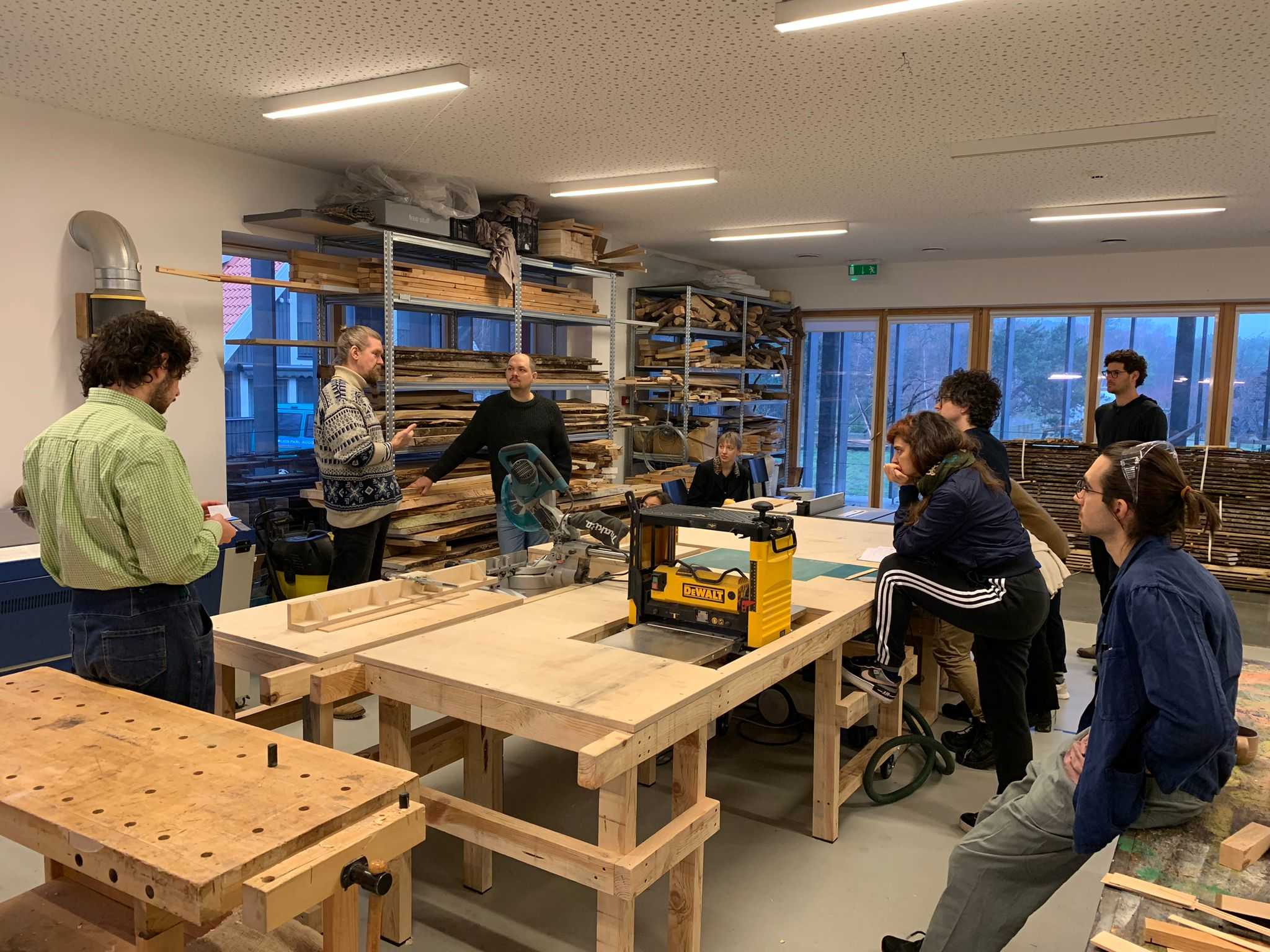 COOP study group - Curating Positions: A cut through the screen getting introduced to NAC's wood workshop facilities by Anton Shramkov. NAC (Nida Art Colony), Nida. January 2023. Photo credit: Peter Sattler.