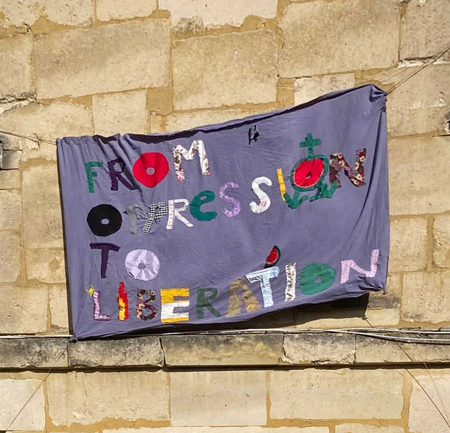 ‘FROM OPPRESSION TO LIBERATION’ BANNER/ ARPILLERA/ TRAPO initiated by Annette Rodriguez Fiorillo  ~ embroidered casually and sewed collectively by Öykü Özgencil, Antonia Truninger, Ariell Zéphyr, Christelle Makris, Mia Tame, Helena Estrela, Maria Miguel Pratas, Davide La Montagna, Kastė Šeškevičiūtė, Peter Sattler, Dalia Maini, Samira Ghoualmia, Tuba Kılıç, Jafar The Superstar among others and carrying the symbols of Palestinian trans solidarity in order the emphasise the importance of 8 March as a day of resistance and solidarity.  It was inspired by a chant from a Palestinian Solidarity Protests in Amsterdam. PAF (St.Erme), March 2024. Photo credit: Helena Estrela. 